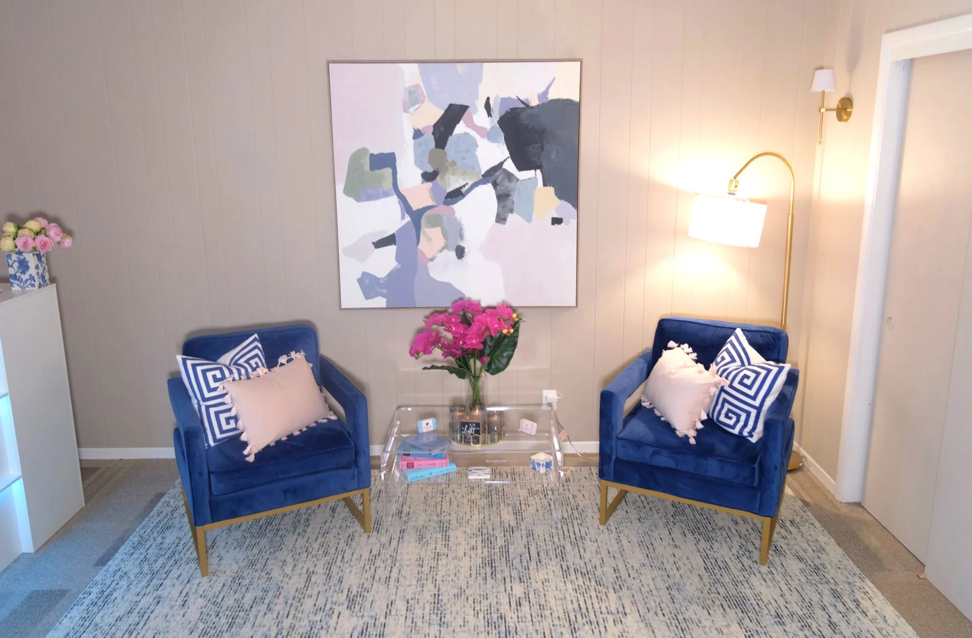 The consultation seating area at Felina Sno Wellness, two velvet chairs beneath abstract art